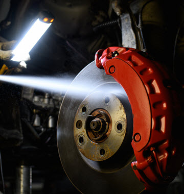Car Mechanic Spraying Disc Brake Fluid Car Mechanic Spraying Disc Brake Fluid